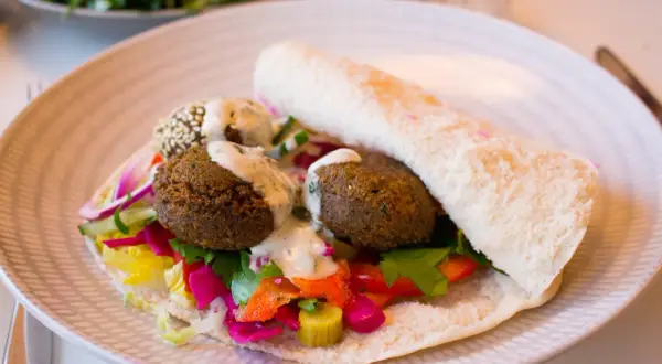 Falafel i pitabröd med färgglada grönsaker och en krämig sås. Ett perfekt falafel recept för en snabb och god lunch.