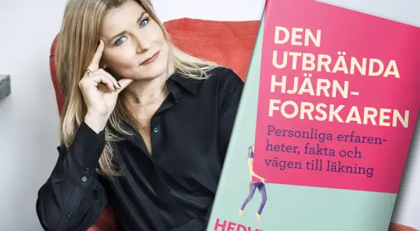 En kvinna med blå ögon och blont hår sitter i en röd fåtölj bredvid boken "Den utbrända hjärnforskaren". Boken handlar om utmattningssyndrom och hur man kan läka.