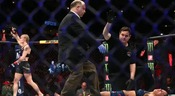 Domaren stoppar matchen. Jessica Eye ligger på mattan medan motståndaren firar.