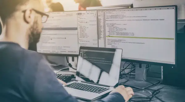 Programista analizuje kod, przygotowując się do pytań rekrutacyjnych tester.