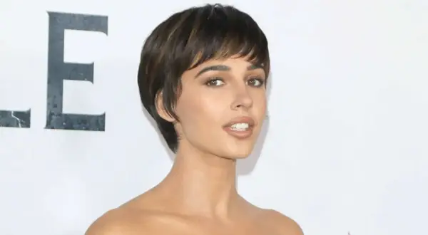 Naomi Scott, mit ihrem markanten Kurzhaarschnitt, strahlt auf dem roten Teppich. Ihre Augen, so klar wie ein christlicher Glaube, fesseln den Betrachter.