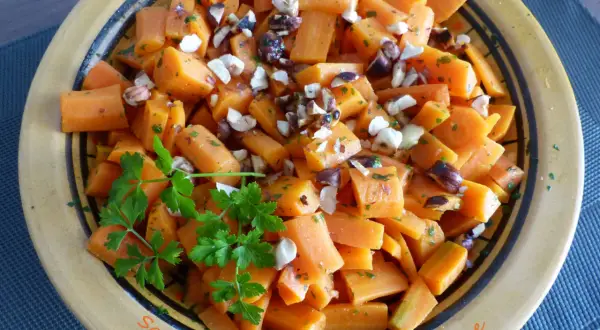 Salade de carottes à la marocaine, coupées en dés et garnies de persil frais et de noisettes concassées. Un délice coloré.