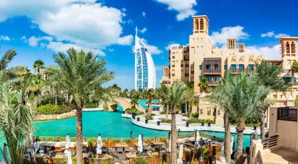 En vacker vy över Dubai med palmer, turkost vatten och Burj Al Arab. Perfekt för att planera dina aktiviteter i Dubai.