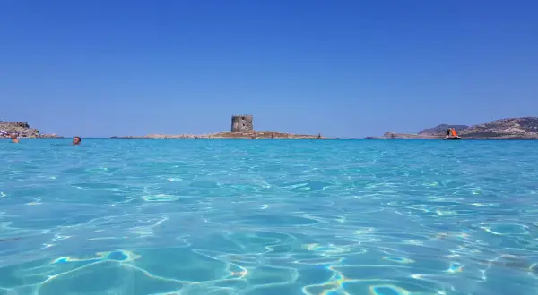 Acque cristalline e un'antica torre in mezzo al mare: uno dei tanti posti di mare belli in Italia.