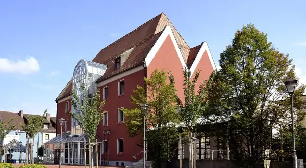 Das Handwerksmuseum Deggendorf präsentiert sich in einem modernen Gebäude mit auffälliger Glasfront und roten Fassaden.