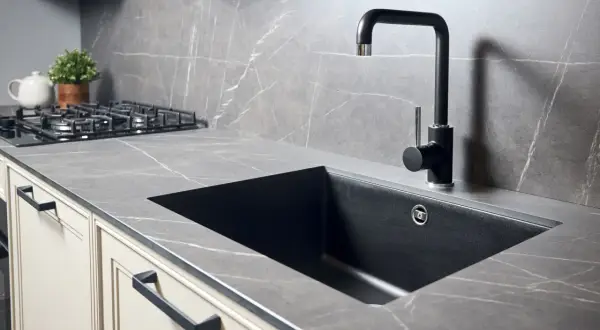 Piano cucina in quarzo effetto marmo con lavello nero e rubinetto moderno. Perfetto per forare top cucina per lavello.