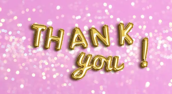 Globos dorados forman "THANK YOU" sobre fondo rosa con luces bokeh. Perfectas frases de agradecimiento para cualquier ocasión.