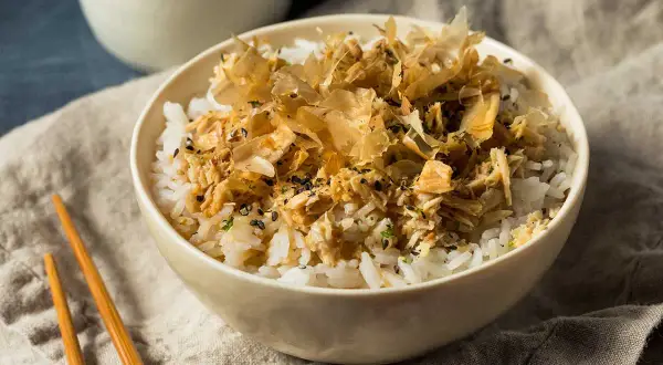 Un tazón de arroz blanco con atún desmenuzado y hojuelas de bonito seco.