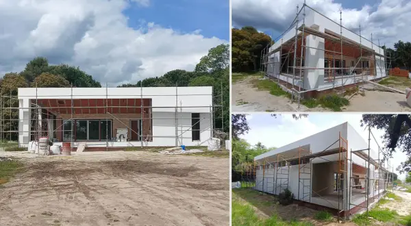 Casa moderna en construcción, con andamios y materiales. Saber que valen los permisos para construir una casa es clave para este proyecto.