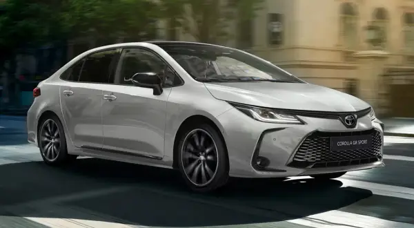 Srebrna Toyota Corolla Hybrid GR Sport 2022 w ruchu miejskim. Sprawdź atrakcyjną toyota corolla hybrid 2022 cena.