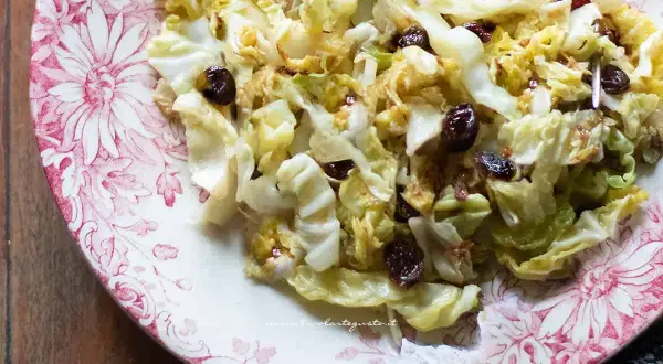 Verza in padella con uvetta, un contorno saporito e colorato servito su un piatto decorato.
