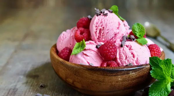 Himbeereis selber machen ohne Eismaschine: Cremiges Eis mit frischen Himbeeren und Minze in Holzschale.