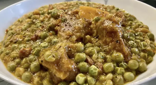 Un saporito spezzatino con piselli, teneri pezzi di carne e verdure in un sugo denso e profumato, pronto per essere gustato.