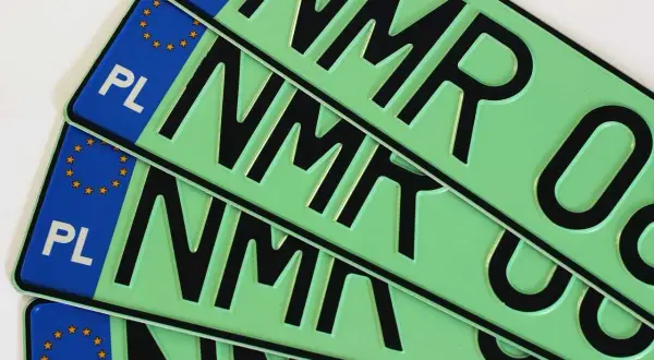 Kilka zielonych tablic rejestracyjnych z literami "NMR" i symbolem Unii Europejskiej.