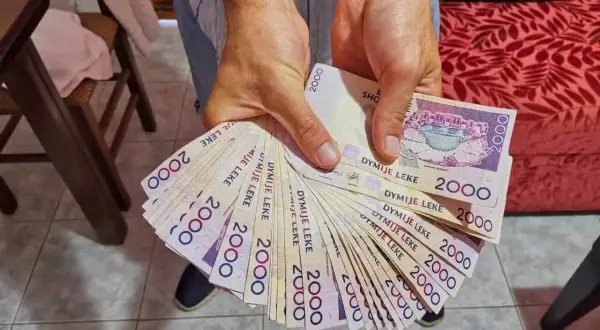 Hände halten einen Fächer aus albanischem Geld, 2000 Lek-Scheine.