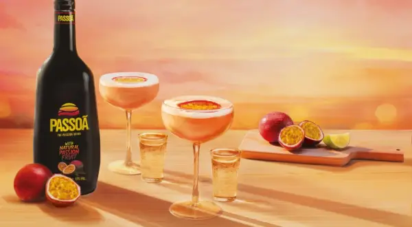 Passoa to alkohol z marakui. Butelka likieru, drinki i świeże owoce na tle zachodzącego słońca.