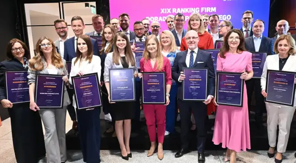 Grupa osób w eleganckich strojach pozuje z dyplomami na tle sceny z logo "Rzeczpospolita".