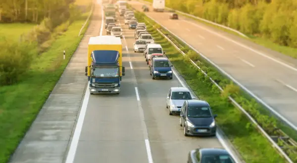 Korek na autostradzie, gdzie samochody i ciężarówka tworzą długi rząd. Kierowcy stosują jazda na suwak, by usprawnić ruch.
