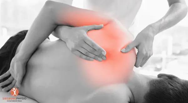 Physiotherapeut behandelt Schmerzen im Schulterbereich, wo ein nerv eingeklemmt sein könnte. Rote Bereiche zeigen die schmerzende Zone.