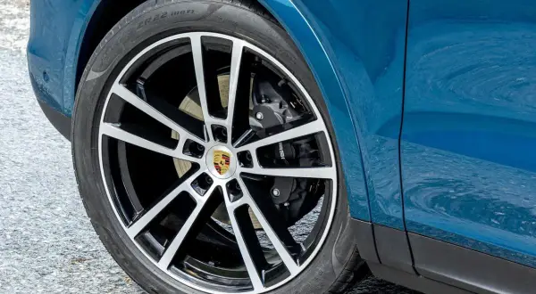 Rueda de Porsche azul con llanta deportiva. Los frenos de alto rendimiento son clave para la distancia de detención y frenado.