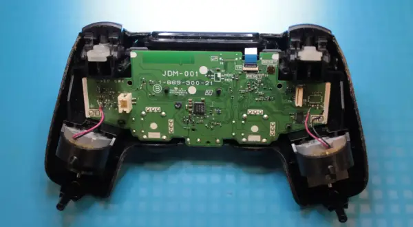 Wnętrze pada PS4 z widoczną płytką drukowaną i elementami. Dowiedz się, jak zresetować pada PS4, gdy napotkasz problemy.