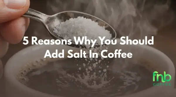 En sked med salt hälls ner i en ångande kaffekopp. Texten "5 Reasons Why You Should Add Salt In Coffee" syns tydligt.