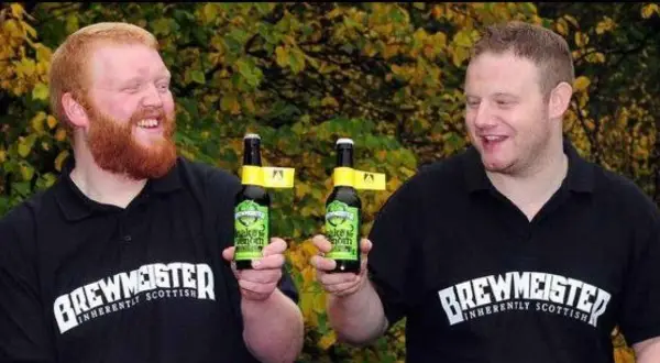 Due uomini sorridono tenendo bottiglie di birra. Potrebbe essere la birra più alcolica del mondo, prodotta da Brewmeister.