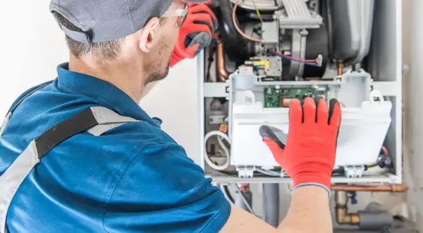 Instalator sprawdza piec gazowy. Dobry piec gazowy do domu 120m2 to klucz do komfortu.