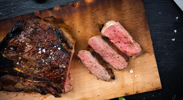 Perfekt gegrilltes T-Bone-Steak, aufgeschnitten, um die ideale Kerntemperatur und saftige Textur zu zeigen.