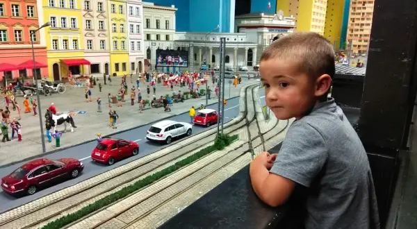 Chłopiec z zaciekawieniem ogląda miniaturową Gliwice. To świetne gliwice atrakcje dla dzieci, gdzie można zobaczyć ruchliwe uliczki i kolorowe budynki.