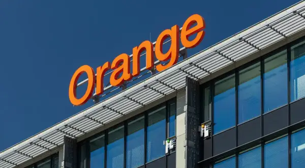 Pomarańczowy napis "Orange" na budynku. Szukasz informacji o telefon stacjonarny Orange cennik?
