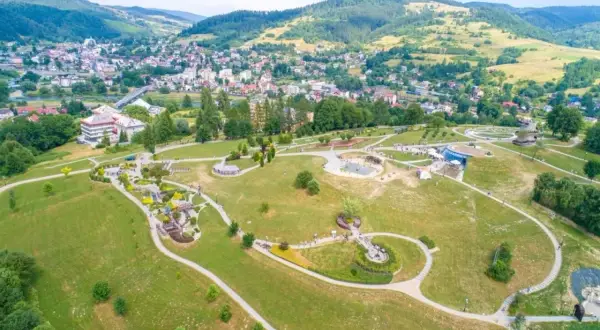 Malowniczy park z alejkami, placem zabaw i wodnymi atrakcjami. W tle widać miasto i góry. To świetne miejsce na rodzinne wycieczki, odkrywając nowe atrakcje Nowego Sącza.