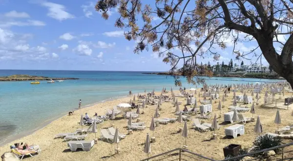 Piękna plaża na Cyprze, z turkusową wodą i rzędami leżaków. To jedno z najpiękniejszych miejsc na wyspie.