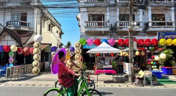 Kolorowe parasolki i tradycyjne stroje w Chiang Mai, gdzie nocować, tworzą festiwalową atmosferę.