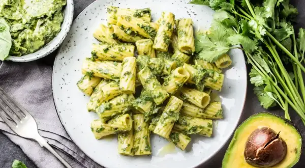 Pyszny makaron rigatoni z zielonym pesto, podany z awokado i świeżą kolendrą. Idealna ilość pesto do makaronu.