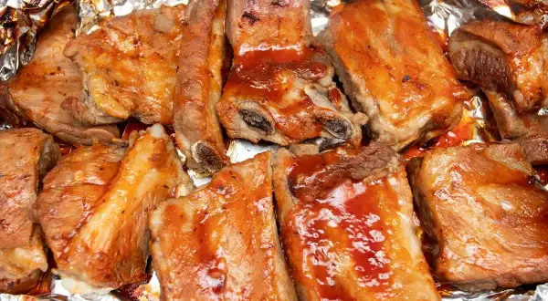 Soczyste żeberka w sosie BBQ, pieczone w folii aluminiowej, kuszą apetycznym wyglądem.