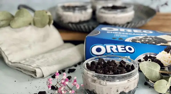 Leckeres Oreo Rezept: Cremige Desserts im Glas, garniert mit zerbröselten Keksen und frischen Kräutern.