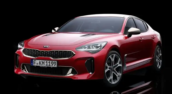 El potente motor del Kia Stinger, un sedán deportivo rojo brillante, se exhibe con su distintiva parrilla y faros LED.