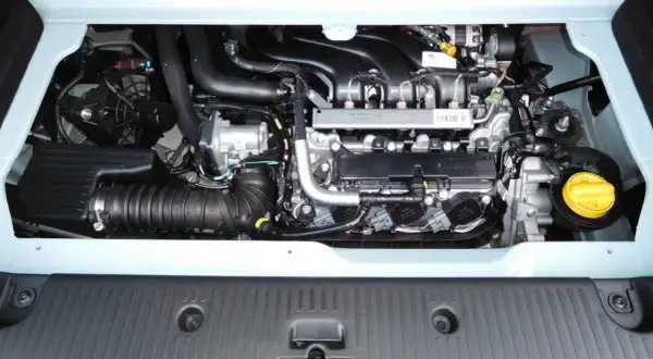 Silnik Renault Twingo 3, widok z góry. Widoczne elementy układu dolotowego, wtryskiwacze i żółty korek płynu.