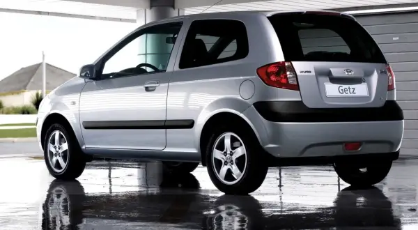Srebrny Hyundai Getz 1.1 z 2005 roku, widok z tyłu, stoi na mokrej nawierzchni.