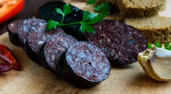 Kaszanka pokrojona w plastry, z pieczywem, czosnkiem i papryką. Czy kaszankę można mrozić? Tak, można ją mrozić.