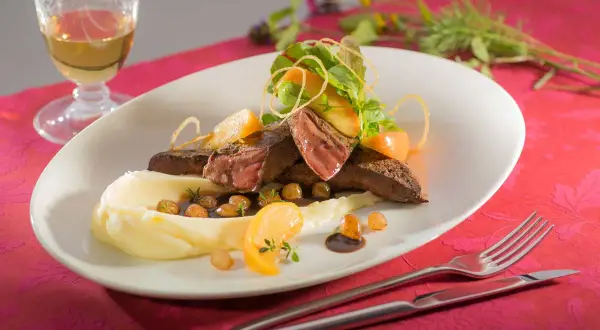 Ein köstliches Kalbsleber Rezept mit Sauce, serviert mit Kartoffelpüree, Apfelspalten und frischen Kräutern.