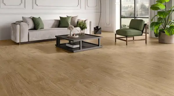 Elegante salón con sofá gris, mesa de centro y sillón verde, sobre un cálido pavimento SPC de madera.