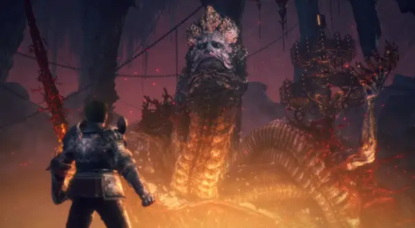 Gracz staje naprzeciw Rykarda, Lorda Węży, w Elden Ring. Ogromny wąż z ludzką twarzą i koroną otoczony jest ogniem i mrokiem.
