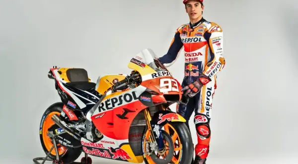 Marc Márquez junto a su moto Repsol Honda, encarnando lo que significa Moto GP: velocidad, pasión y tecnología punta.
