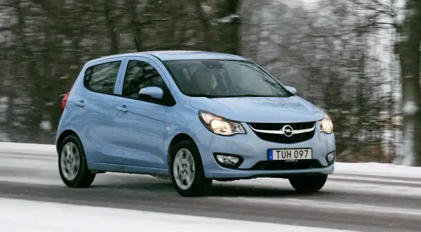 Ljusblå Opel Karl kör på en snöig väg.