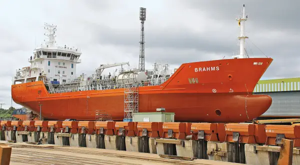 Orange product tanker "BRAHMS" in dry dock, ready for maintenance.