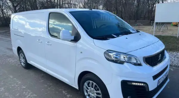 Biały Peugeot Expert 2.0 HDI gotowy do pracy. W tle drzewa i plac zabaw.