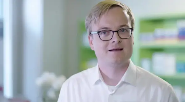 Ein Mann mit Brille in einem weißen Hemd spricht. Er erklärt, dass es erleada eine Chemotherapie ist.