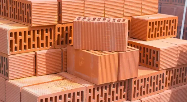 Stos pustaków ceramicznych, idealnych do budowy domu energooszczędnego. Zastanawiasz się, z czego budować dom energooszczędny: pustak ceramiczny czy gazobeton?